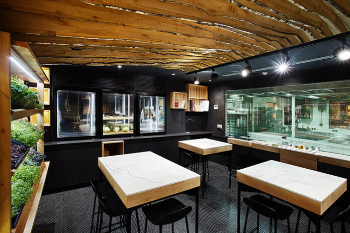 El Estudio es un espacio que conecta la cocina y la sala a través de cristaleras en el restaurante.|El restaurante propone a través del baúl de viaje del Travel Wine Experience un recorrido vinícola por el mundo.